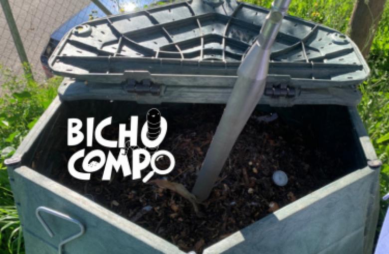 Imagen de una especie de papelera en forma pentagonal y color gris con compost en su interior