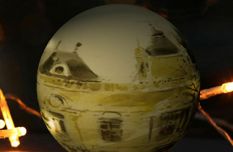 Bola de navidad en tonos grisáceos en la que se ve de fondo reflejada la Casa Amarilla de la EEZ